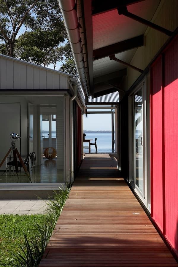 A Wooden Walkway Between Two Buildings With A View Of The Ocean — South Coast Glass In South Nowra, NSW