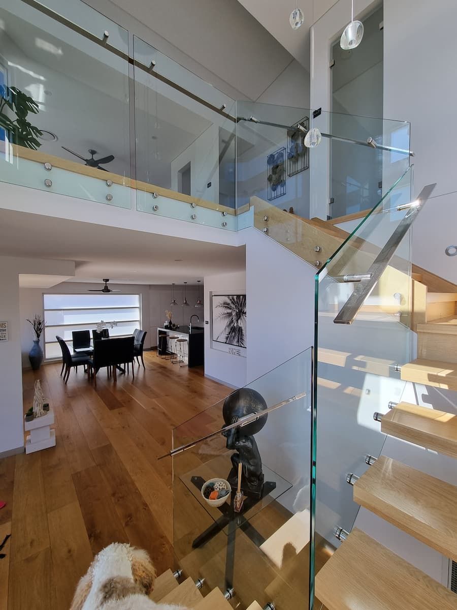 A Dog Is Sitting On The Stairs In A House — South Coast Glass In South Nowra, NSW