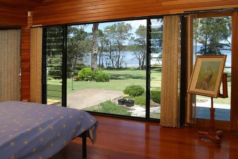 A Bedroom With A Large Window And A Painting On A Stand — South Coast Glass In South Nowra, NSW