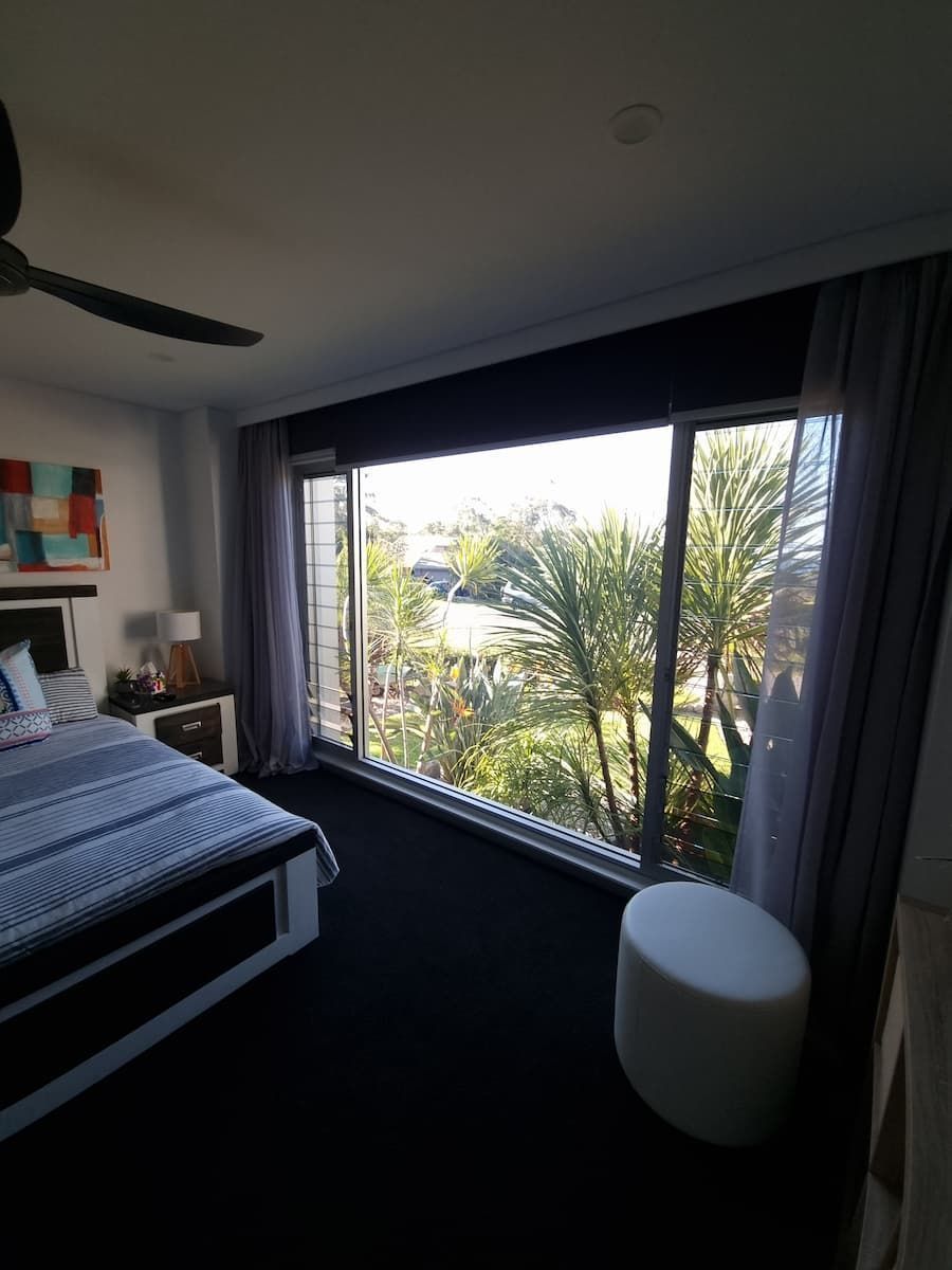 A Bedroom With A Large Window And A Ceiling Fan — South Coast Glass In South Nowra, NSW