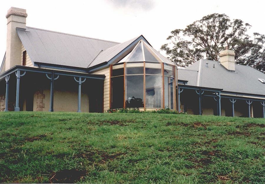 A Large House Sits On Top Of A Grassy Hill — South Coast Glass In South Nowra, NSW
