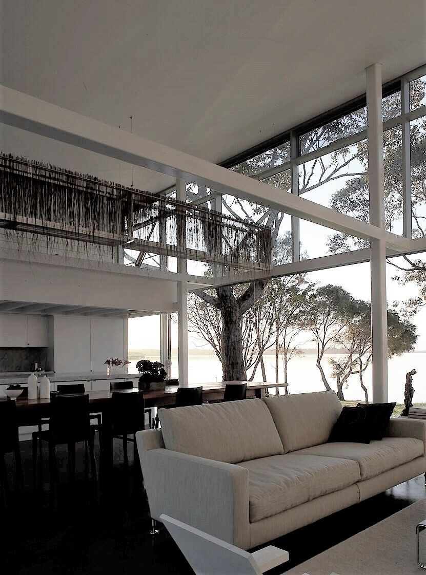 Spacious living room with large windows, white sofa, and a view of trees and a body of water — South Coast Glass In South Nowra, NSW