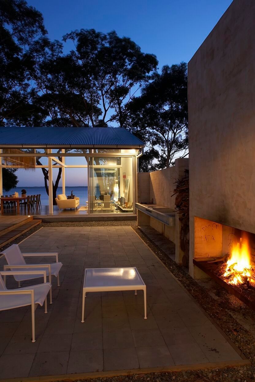 A Patio With A Fireplace And Chairs At Night — South Coast Glass In Berry, NSW