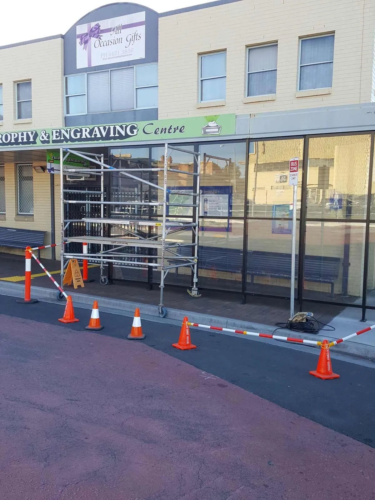 Scaffolding in front of a storefront with a sign that reads "Quality Engraving Centre." — South Coast Glass In South Nowra, NSW