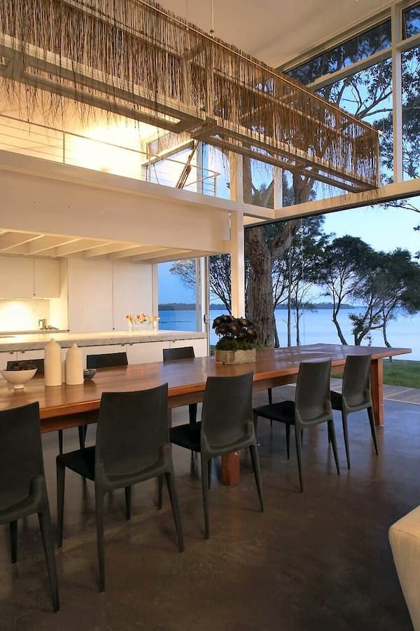 A Dining Room Table And Chairs In A House With A View Of The Water — South Coast Glass In South Nowra, NSW