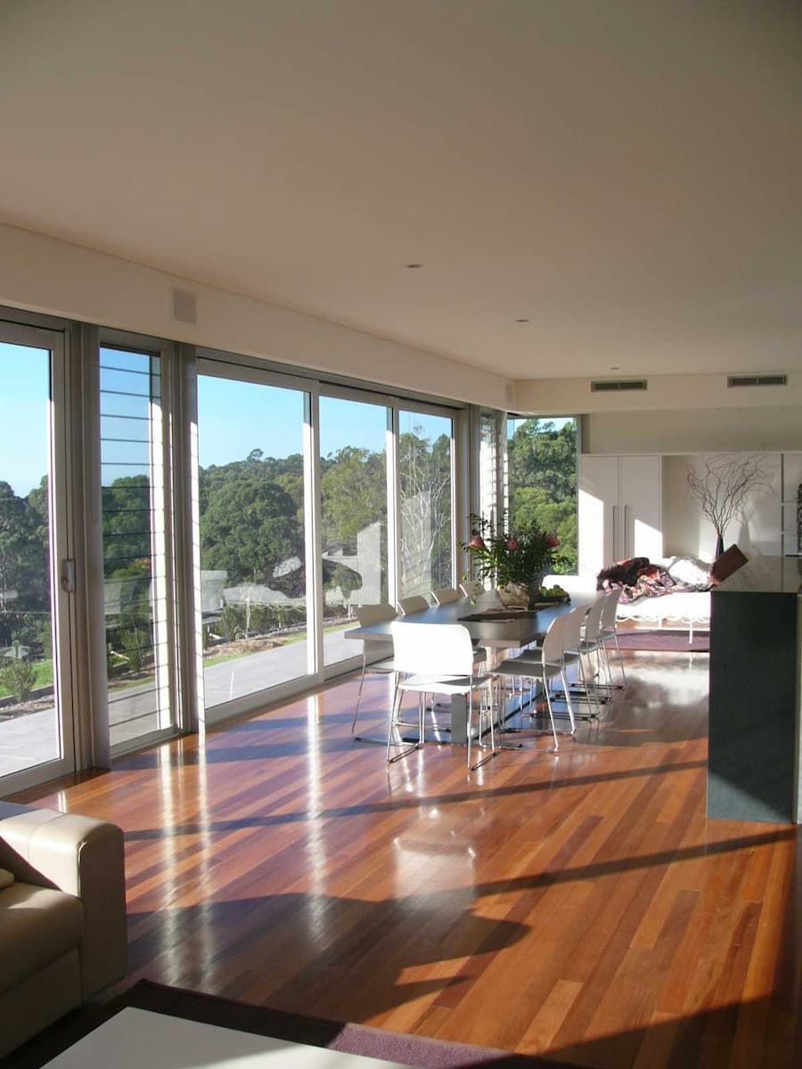 A Living Room With Hardwood Floors And Lots Of Windows — South Coast Glass In South Nowra, NSW