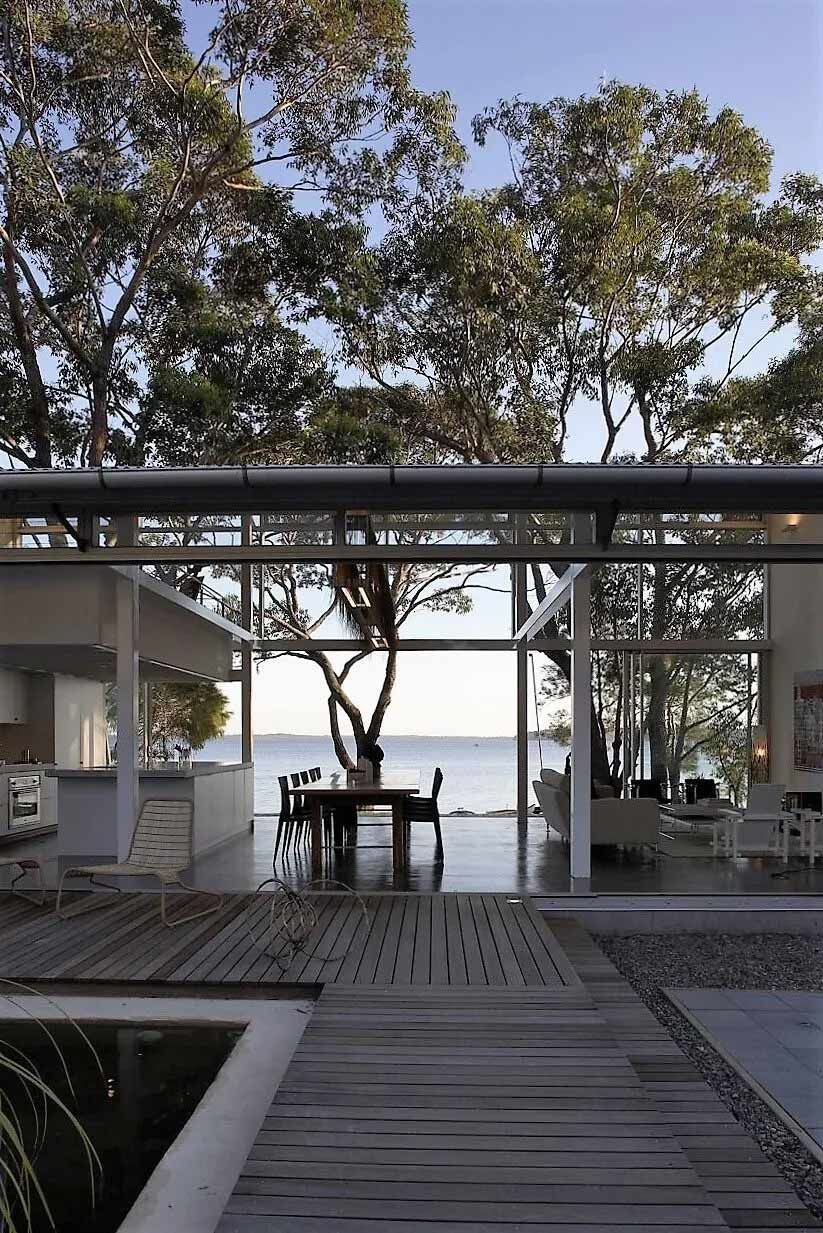 Modern home with glass walls overlooking the sea and a wooden walkway — South Coast Glass In South Nowra, NSW
