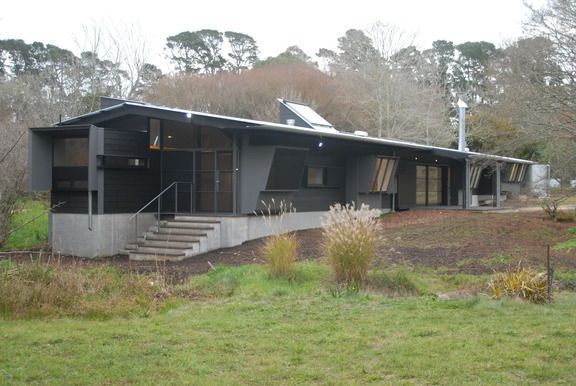 A Large Black House Is Sitting In The Middle Of A Grassy Field — South Coast Glass In South Nowra, NSW