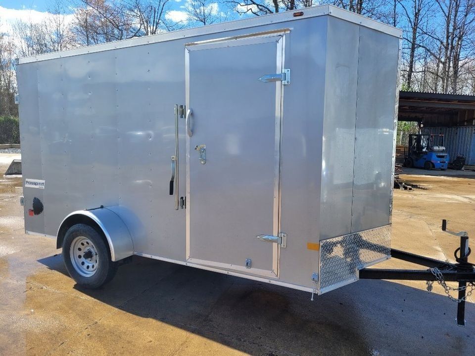 Silver enclosed utility trailer with a side door, parked outdoors. | Gainesville Garage & Trailer Sales