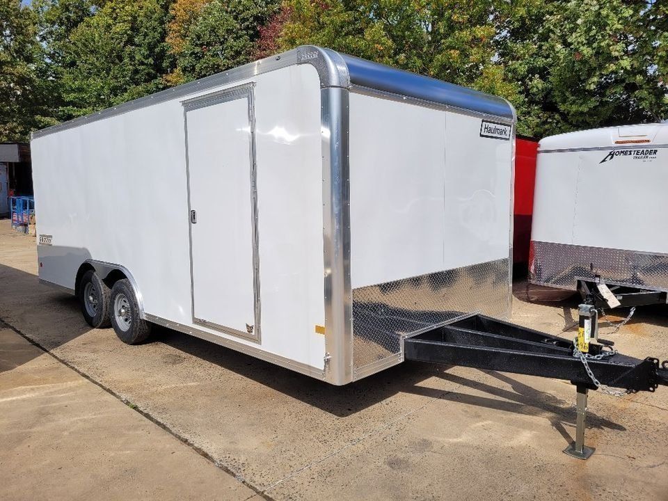 White enclosed cargo trailer with black trailer hitch, parked outside.