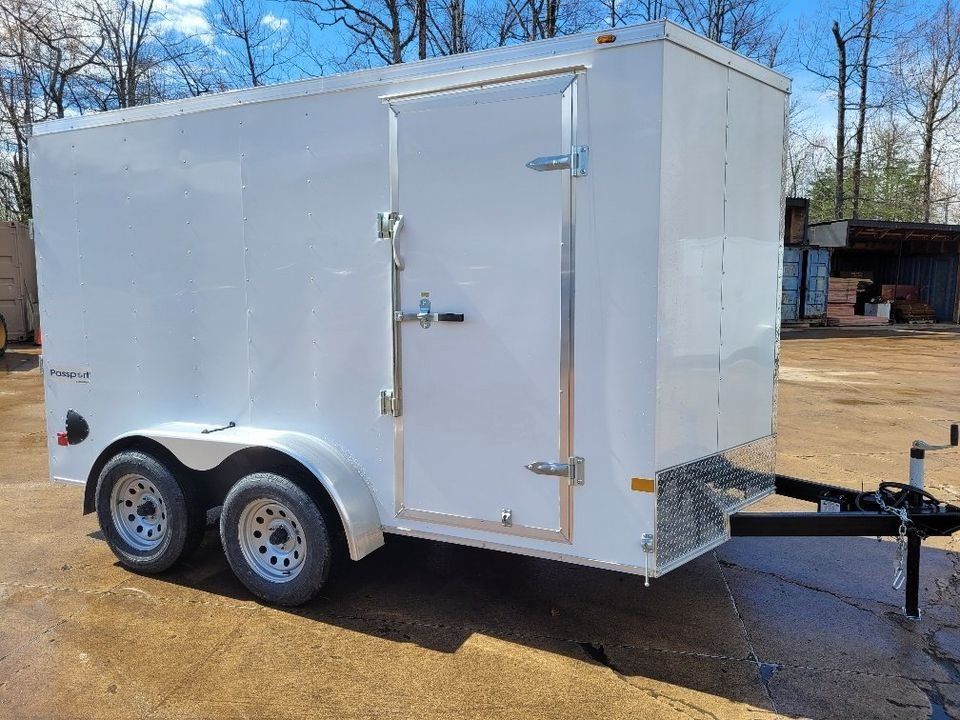 White enclosed cargo trailer, with dual wheels, parked on a sunny day. | Gainesville Garage & Trailer Sales