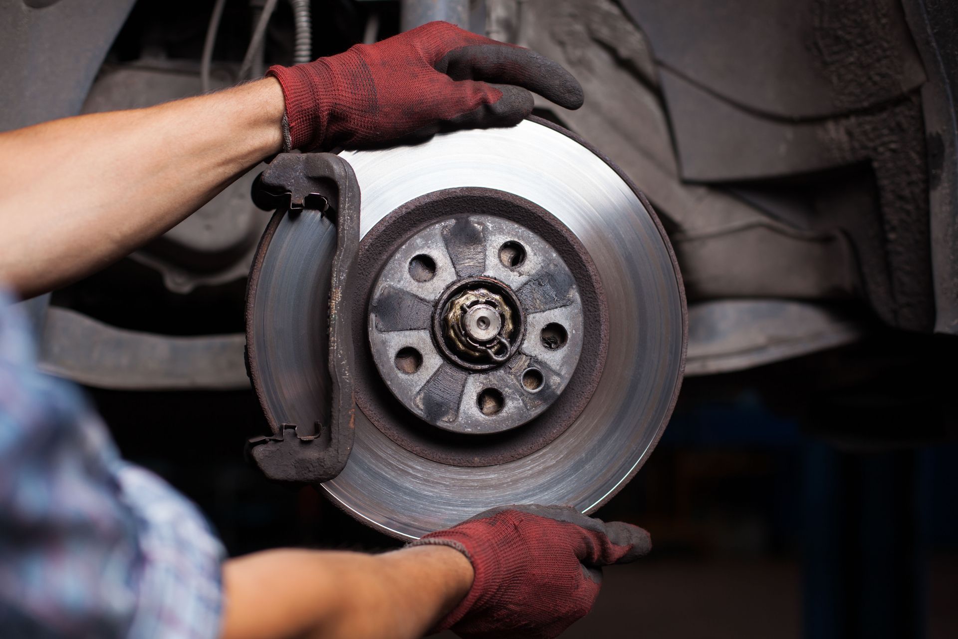 A person is fixing a brake disc on a car.