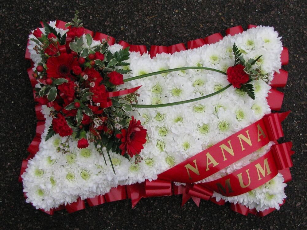 6. 18” White Pillow with red ribbon edge, red ribbon sash’s and red posies