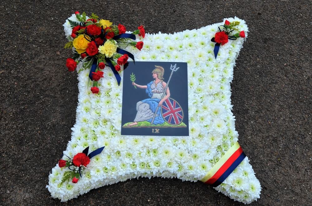 6. 23” white Cushion with the Royal Norfolk Regiment emblem to the centre and the colours in posies/ribbon to match