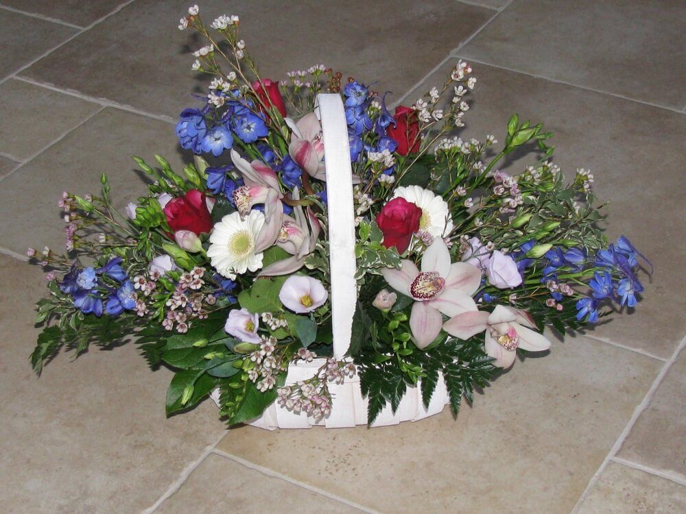 3.  Trug Basket of Delphinium, Orchids, Germini, Waxflowers and Roses