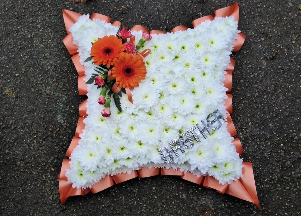 4.  15” Cushion with orange ribbon edge, orange Germini and Dianthus posy and Aluminuim letters