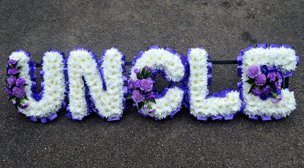 16. Purple and white UNCLE with white letters and purple Carnations