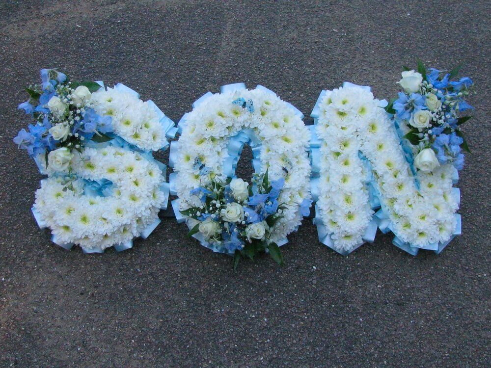 22. SON in White letters with pale blue ribbon edge and Delphiniums, white Rosebuds and tiny blue Butterfly