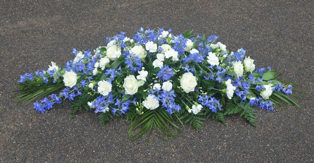 52. White and blue coffin spray with Delphiniums, Roses, Carnations and Dianthus