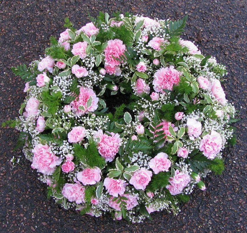 10.  12” pink wreath of Carnations and Gypsophila