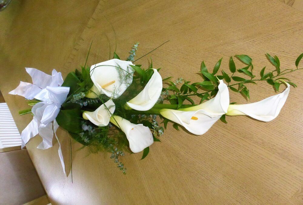 14. Arum Lily Sheaf with foliage and grasses tied with white Ribbon