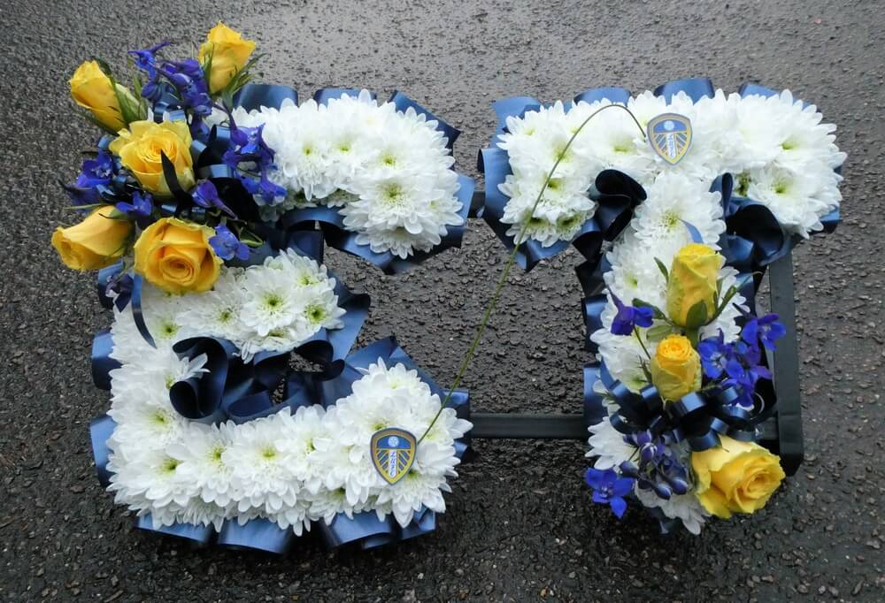 1.  White letters with yellow Roses and blue Delphinium