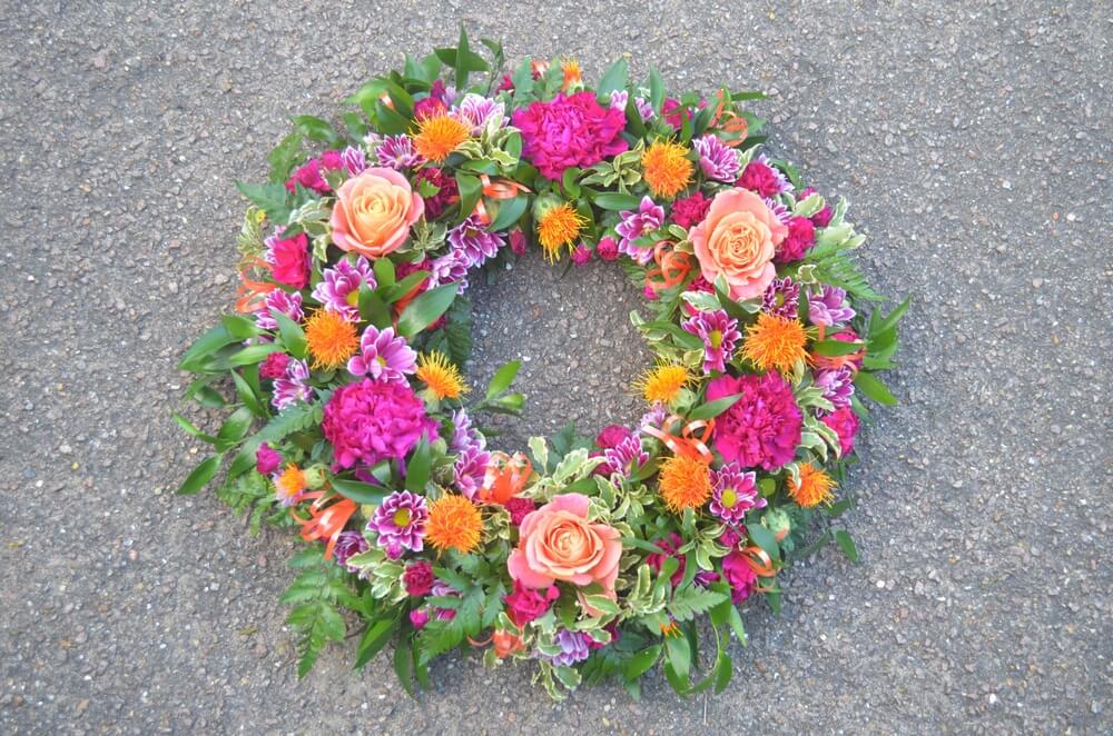 1.  14” purple Carnation, orange Rose and Carthamus Thistle wreath