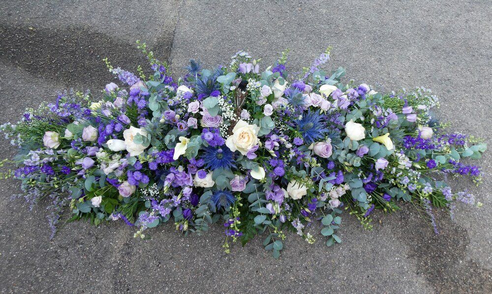 53. Special full coffin spray in purples and lilac with cream David Austen Roses included