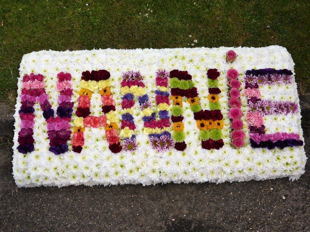 74.  4ft long design board with NANNIE in brightly coloured flowers