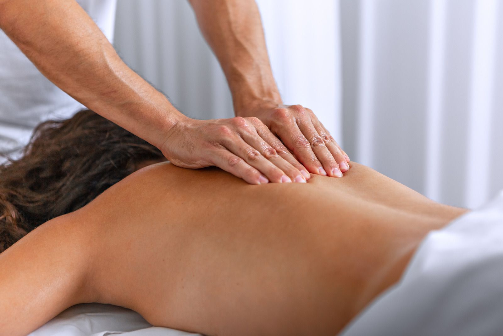 A woman is getting a massage from a man in a spa.