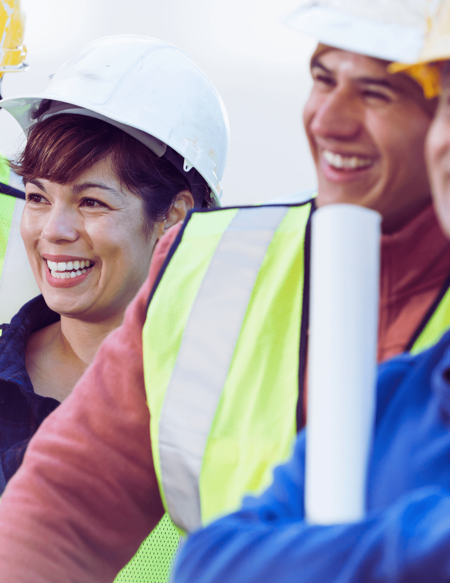 a group of construction workers are smiling and holding blueprints .