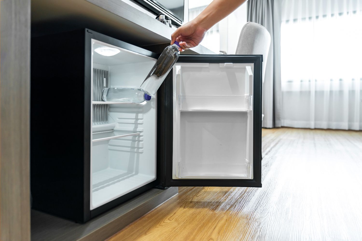 Uma pequena geladeira está em uma sala ao lado de uma janela.-Pousada-Morada-dos-Passaros