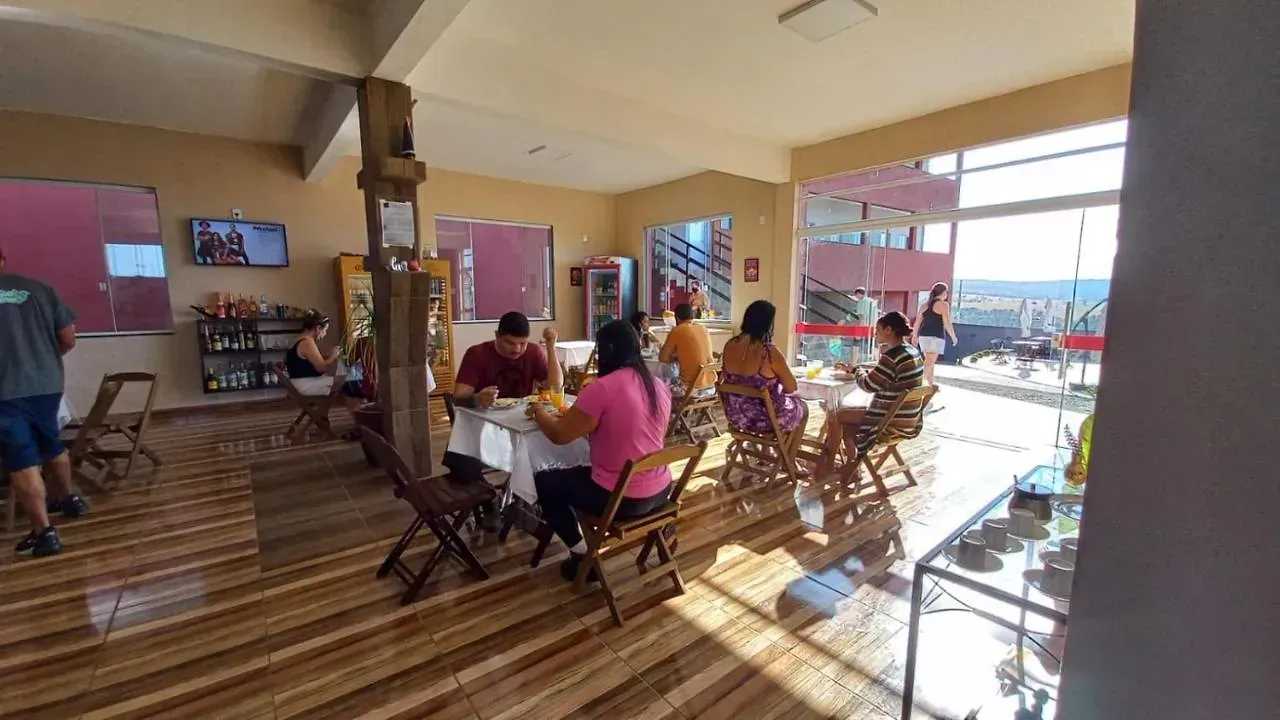 Um grupo de pessoas está sentado em mesas em um restaurante.-Pousada-Morada-dos-Passaros