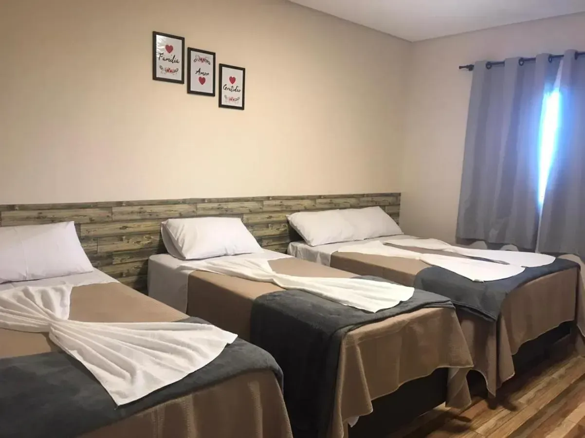 Um quarto de hotel com três camas e uma janela.-Pousada-Morada-dos-Passaros