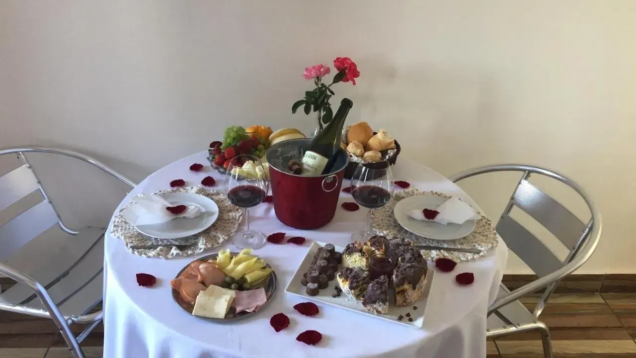 Uma mesa com pratos e uma garrafa de vinho sobre ela-Pousada-Morada-dos-Passaros