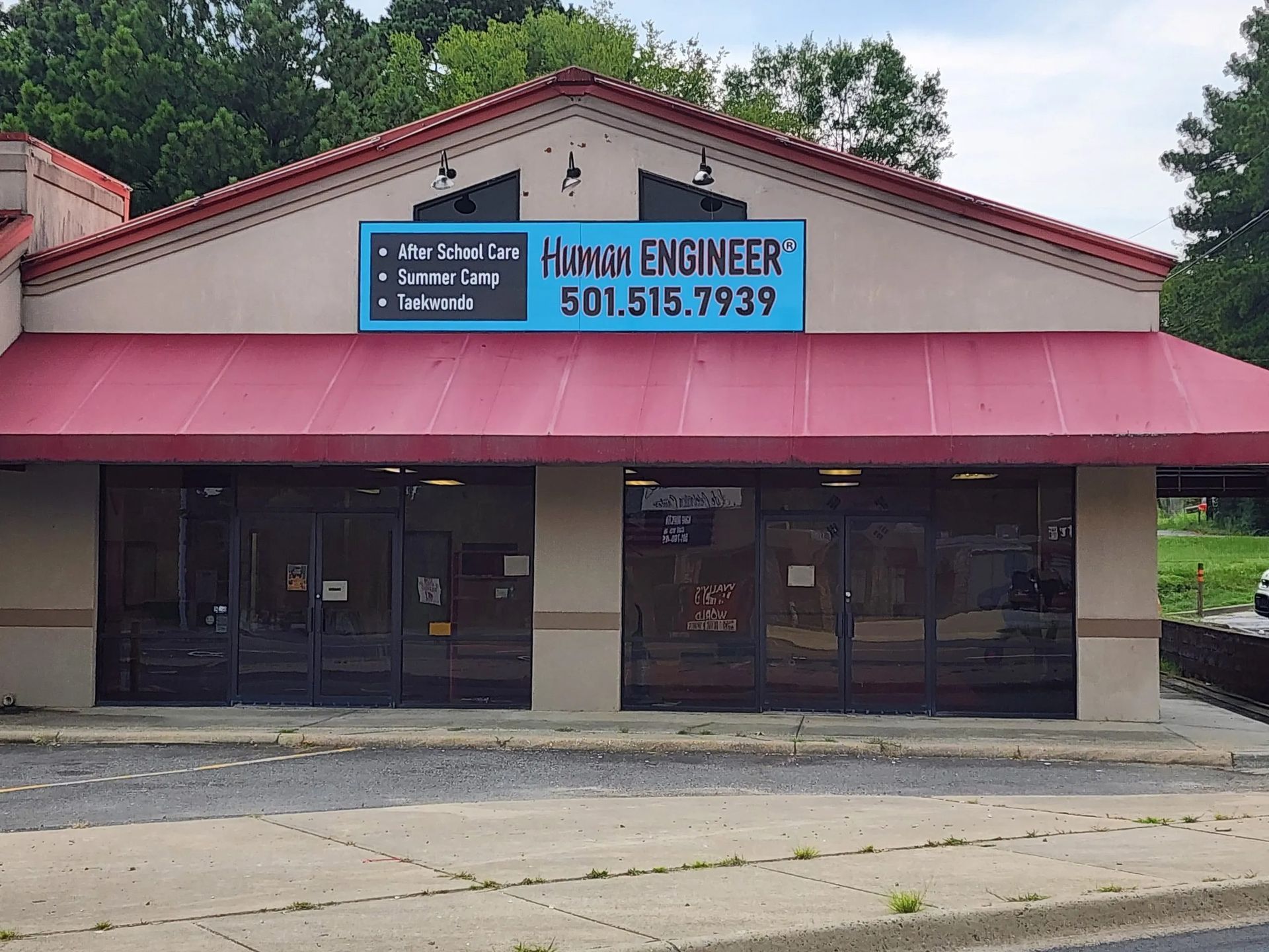 Storefront with red awning and sign that reads 