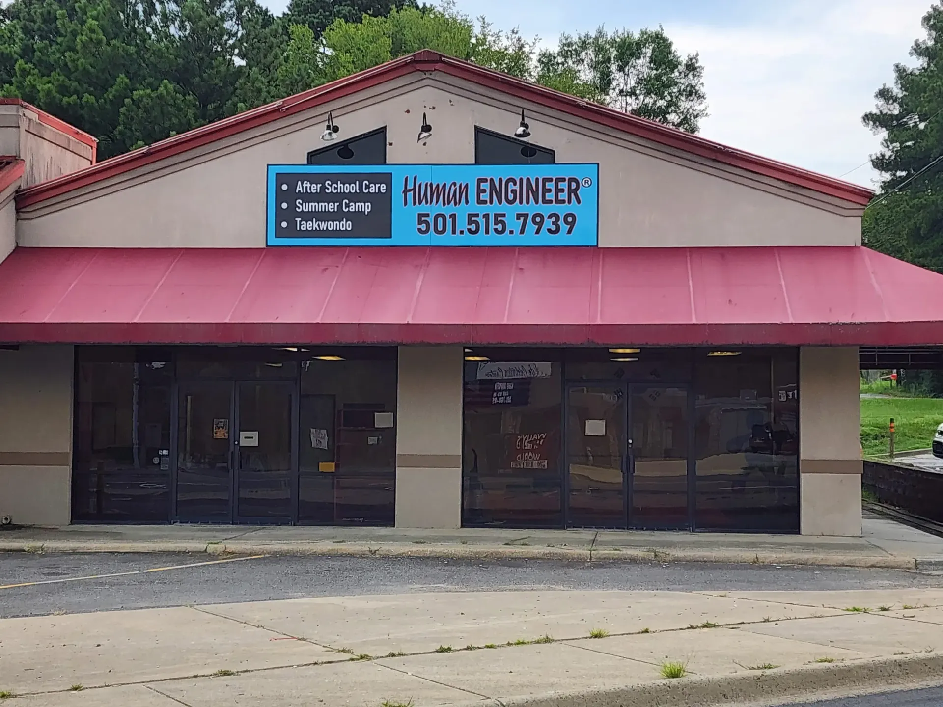Building storefront with red awning, sign reads 