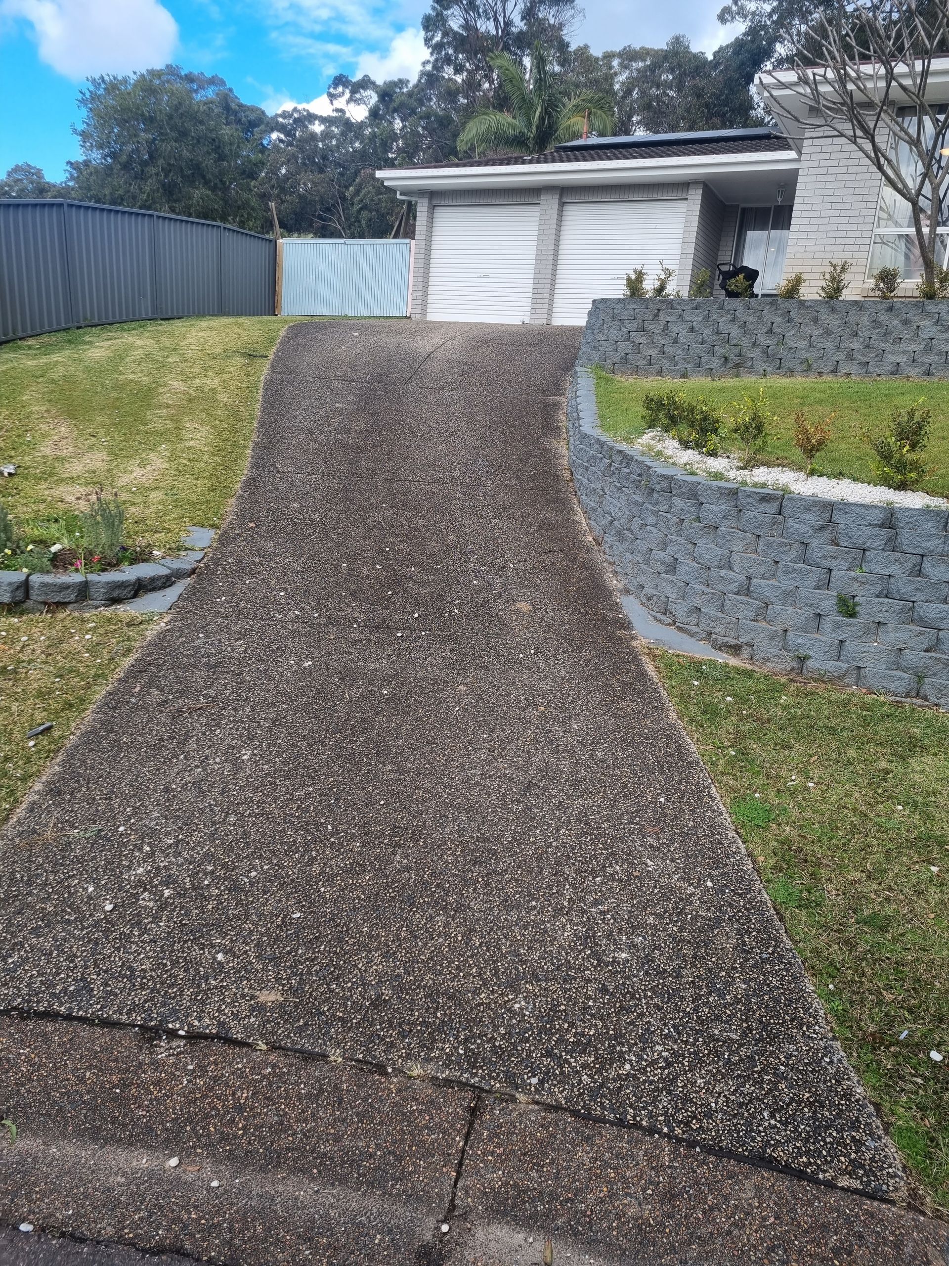 A Concrete Walkway Leading Up to a House on a Hill — All Clean Pressure Cleaning in Valentine, NSW