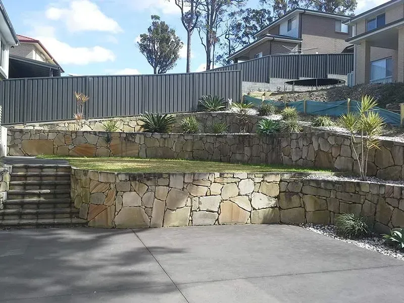 A Driveway With a Stone Wall and Stairs Leading Up to It — All Clean Pressure Cleaning in Valentine, NSW