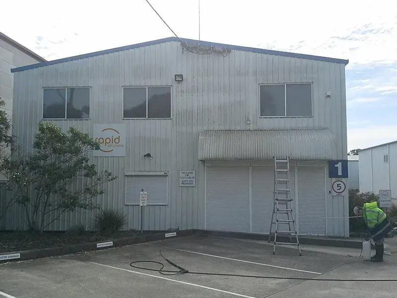 A Large White Building With a Ladder in Front of It — All Clean Pressure Cleaning in Valentine, NSW