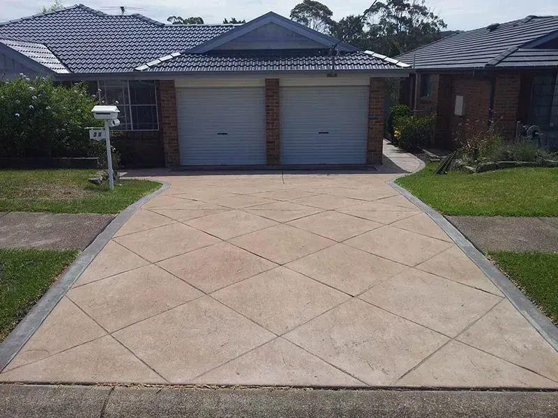 A Driveway Leading to a House With Two Garage Doors — All Clean Pressure Cleaning in Valentine, NSW