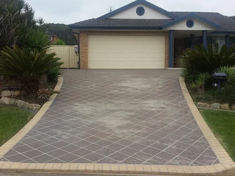 A Driveway Leading to a House With a White Garage Door — All Clean Pressure Cleaning in Valentine, NSW