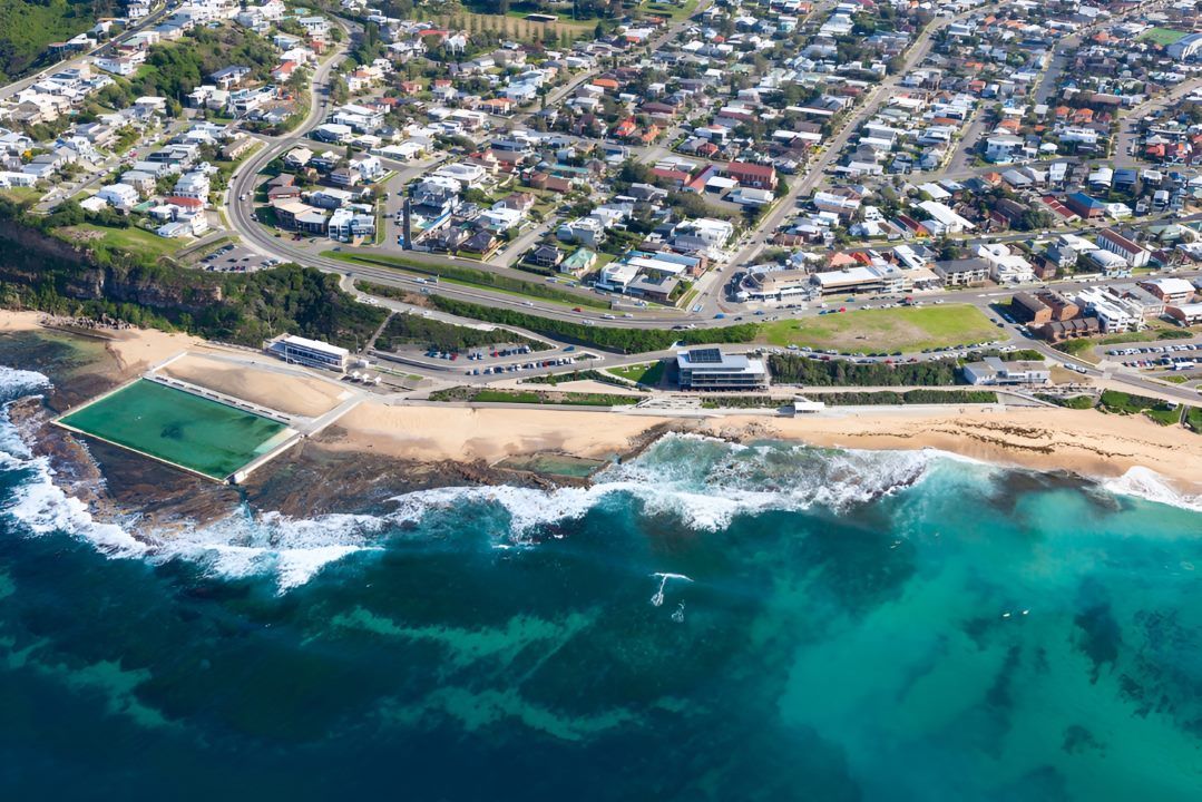 An Aerial View of a Beach With a Swimming Pool and a City in the Background — All Clean Pressure Cleaning in Merewhether, NSW