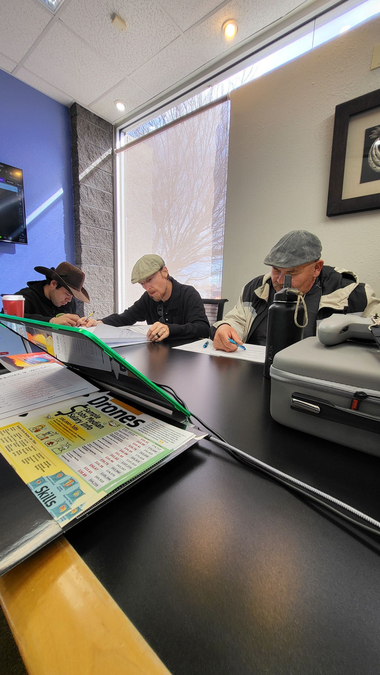 Three students taking a mock FAA Part 107 exam during drone pilot training in El Paso.