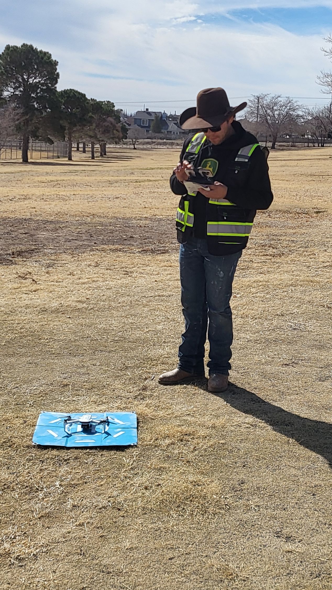 Drone training student in reflective vest flying a drone during FAA Part 107 practice in El Paso.