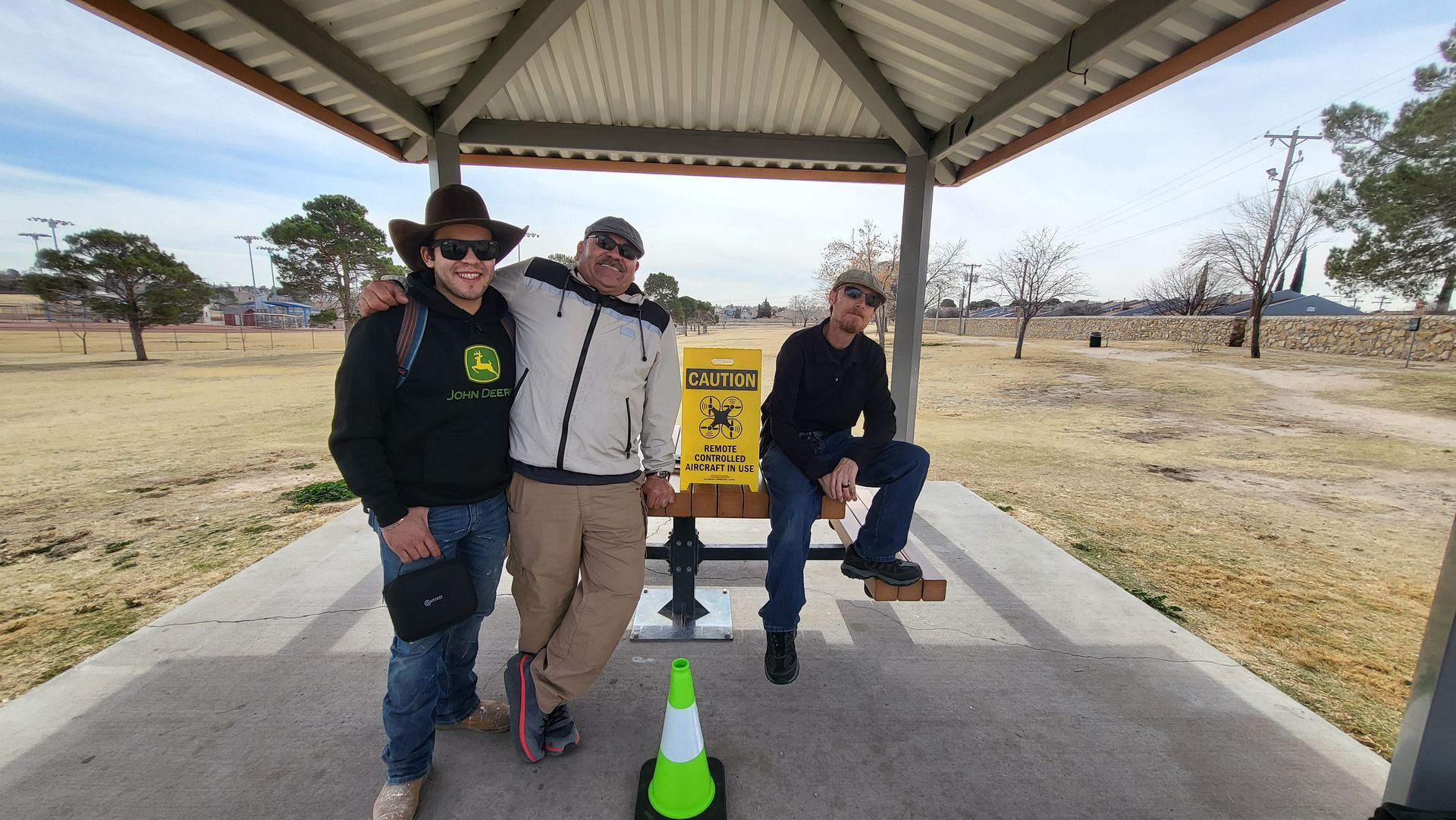 Three members of Class 2601 “Three Amigos” posing together at a park shelter after completing drone pilot training in El Paso.