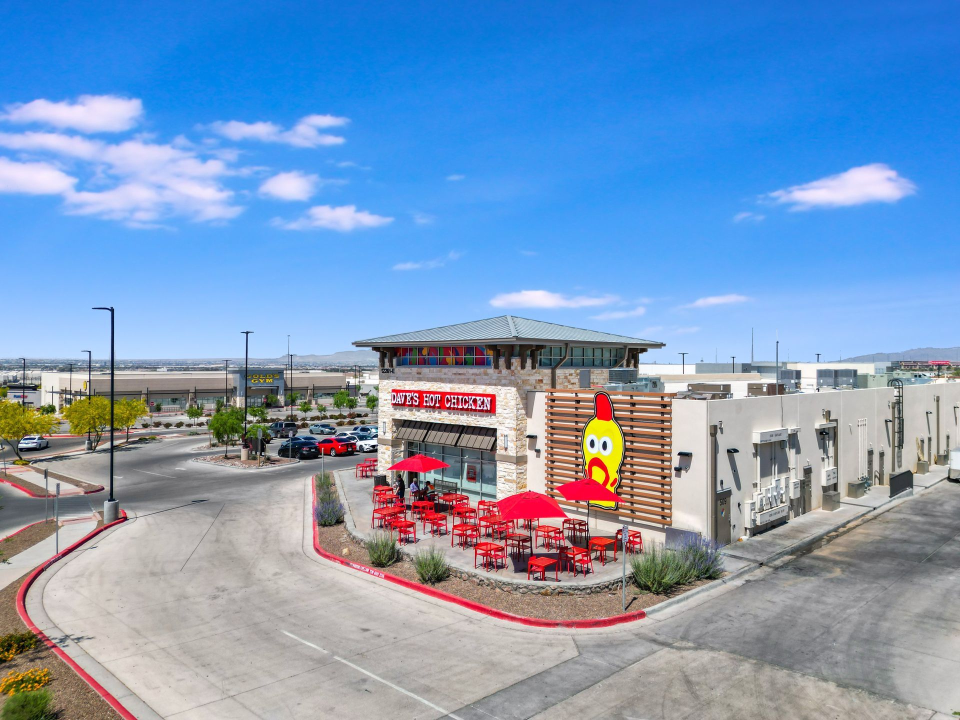 Outdoor patio dining area at Dave’s Hot Chicken with branded seating and street-facing visibility