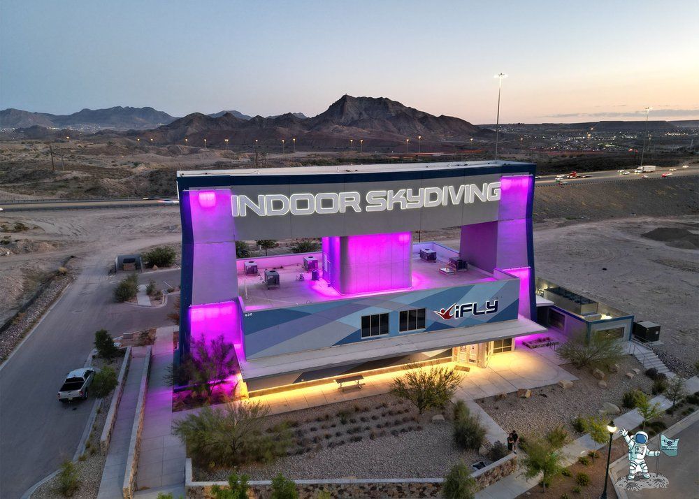 Aerial view of iFLY El Paso at sunset with glowing neon lights, showcasing the El Paso landscape in the background, captured by From Above Droneworks.