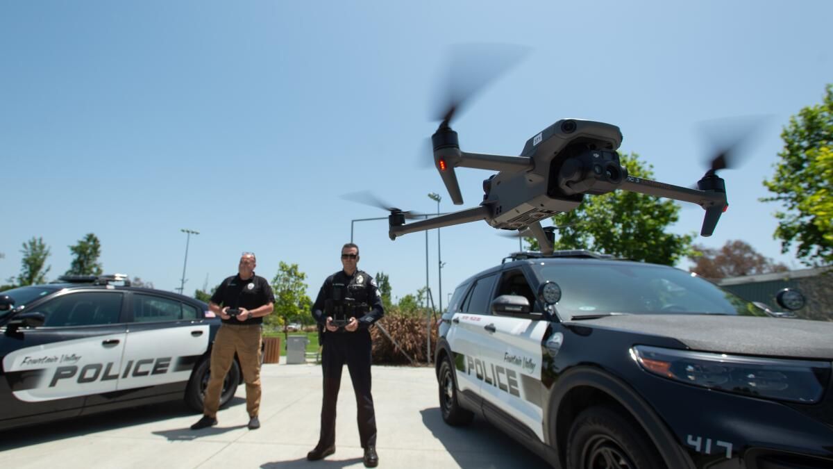 Police officers launching a drone from patrol vehicle during daytime flight training