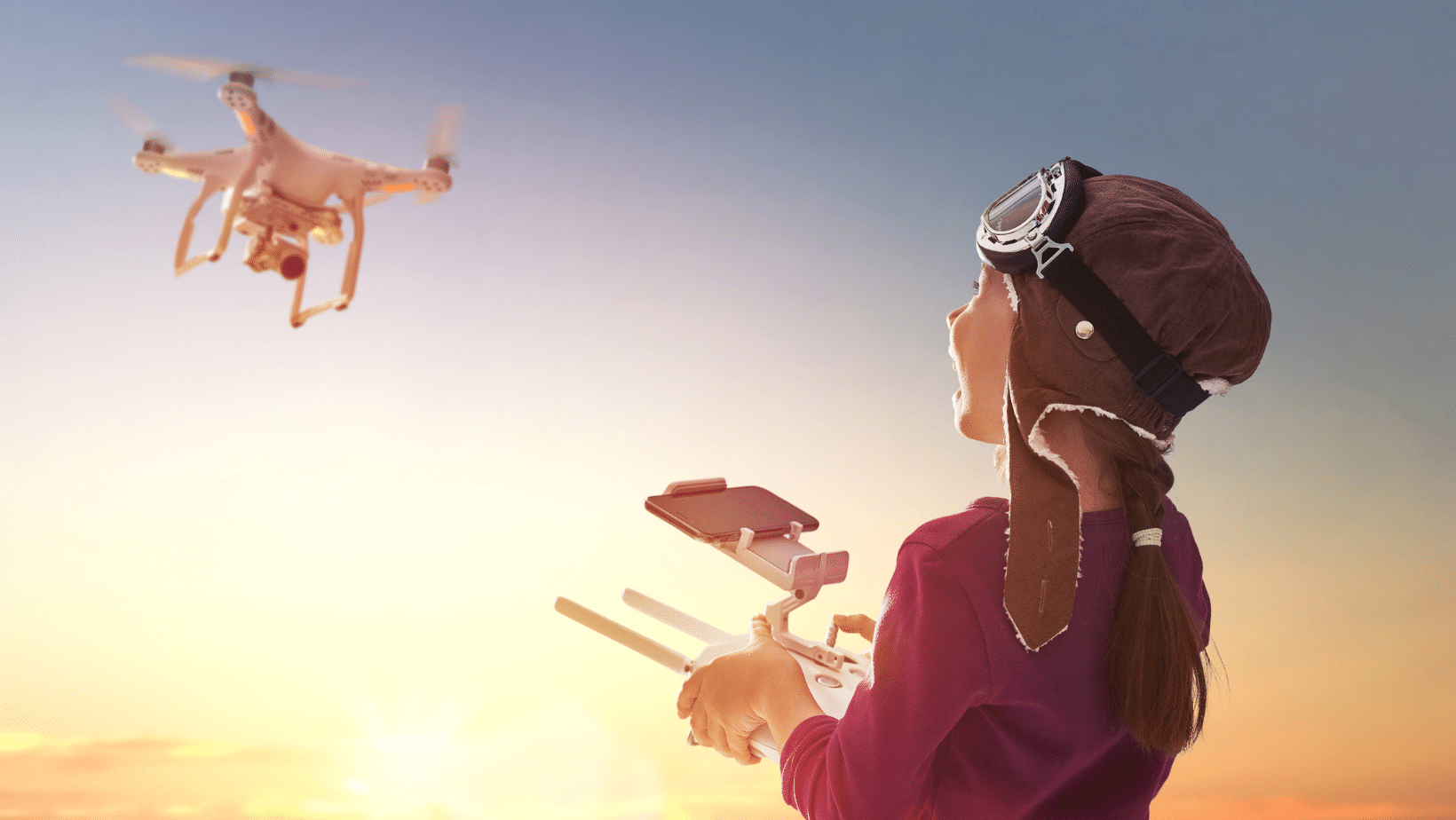 Child in pilot hat flying a drone